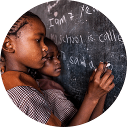 student writing on black board in Liberia